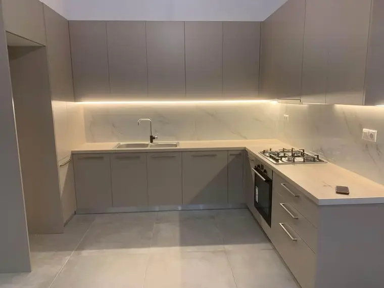 The renovated three-bedroom: the kitchen and the living area, photographed empty after the renovation