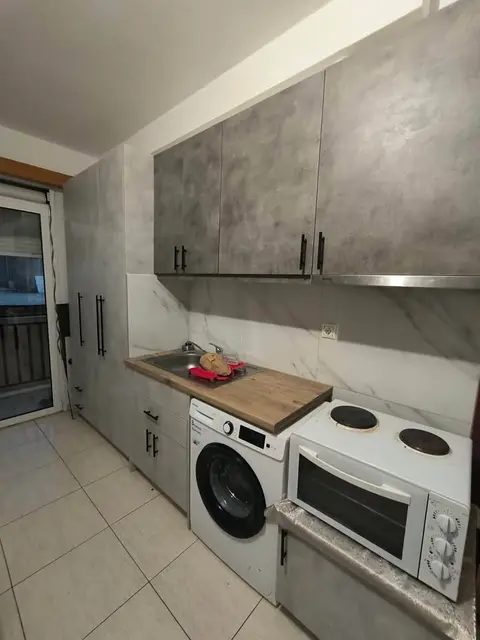 The alcove studio: the kitchen, the washing machine and the door to the balcony
