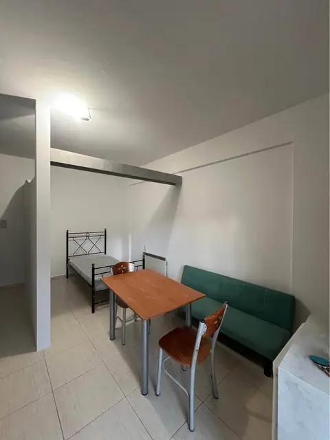 The alcove studio: the bed in its alcove, past the table